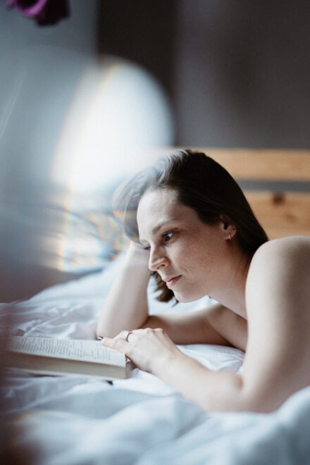 Jeu de lumière avec un prisme d'une femme lisant un livre allongée sur un lit