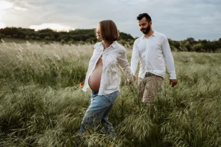 Future maman et papa marchant dans un champ de provence
